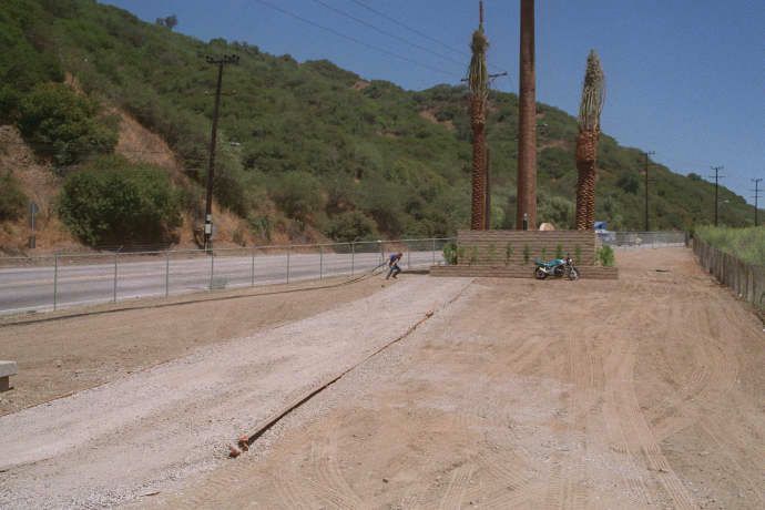 Getting ready for pulling the coax cables up the tree
The worker prepares the coax cables for insertion into the trunk of the monopalm by laying them out flat on the ground.  From here, a pull rope will be used to raise the cables into the trunk, and up to the level of the antennas.
Keywords: pull coax cables up monopalm rope