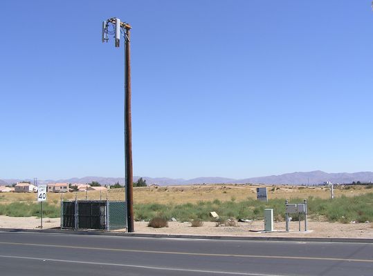 Got Desert?
This little Verizon 3-sector site sites atop a wood pole in Victorville, California.  The BTS equipment is in the fenced area to the left, and the telco and power panels are to the right.
Keywords: victorville california verizon wood pole sector