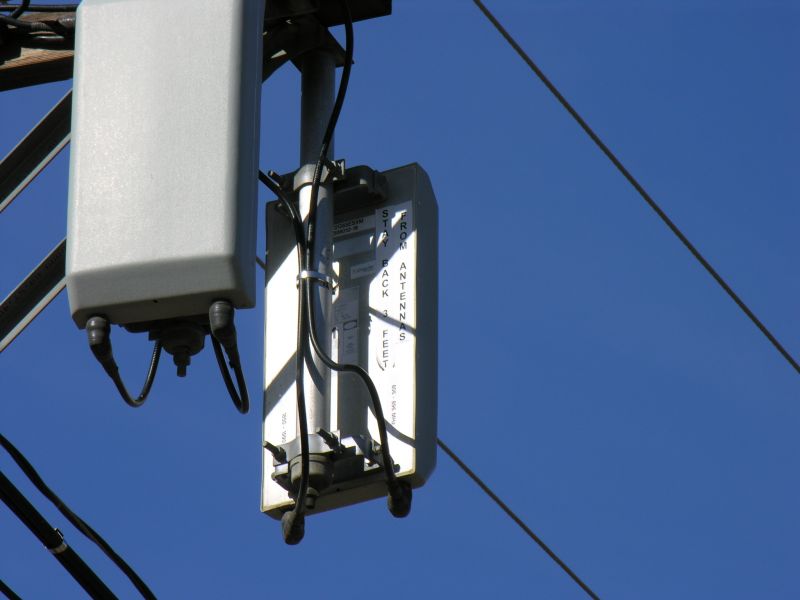 Das da ticket!
A close up of the AT&T Wireless DAS antennas.  Note several things: 

First, the RF warning sign is on the rear of the antenna, where is cannot be seen by someone approaching the antenna.  This is not consistent with the FCC RF safety requirements.

Second, these are dual band antennas.  In the far antenna, the cellular band antenna feed is on the right; the PCS band feed is on the left.
Keywords: das distributed antenna system node andrew corporation power meter pedestal cabinet rf safety warning sign dual band cellular pcs