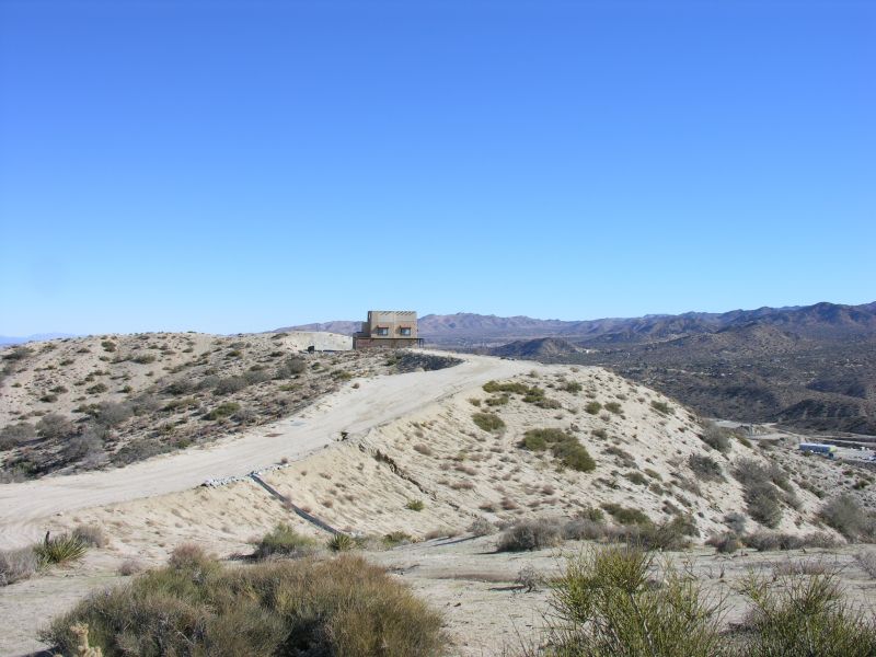 Wireless Adobe
Approaching Cingular's wireless adobe site from the west side service road.  It's on a bluff above California Highway 62 southeast of Yucca Valley, California.  It appears to be 'just another house on a hill' until you get up close and personal.  The site is owned by InterConnect Towers LLC (FCC ASR 1050520).
Keywords: cingular yucca valley california adobe interconnect towers llc