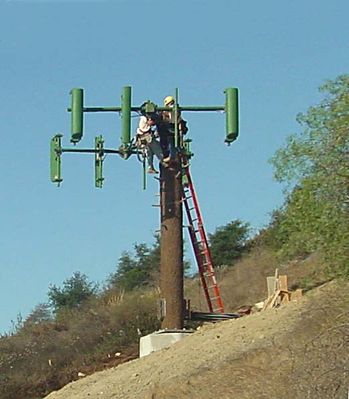 07 - Antennas Installed, Connected
The techs have installed the panel antennas on the arms, and are now connecting the coaxial cables to the antennas.
