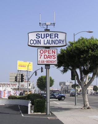 Omni-directional Microcell on Sign
This AT&T Wireless site, at Fairfax and Pico in Los Angeles, is an example of placing a microcell site atop an existing, small sign.  

If you enlarge the photo, don't miss checking out the lid of the vault in front of the pole.  The lid is a piece of plywood, apparently to replace the original concrete!  

Nope, I don't want to drive my car over that lid, either!
Keywords: microcell AT&T Wireless