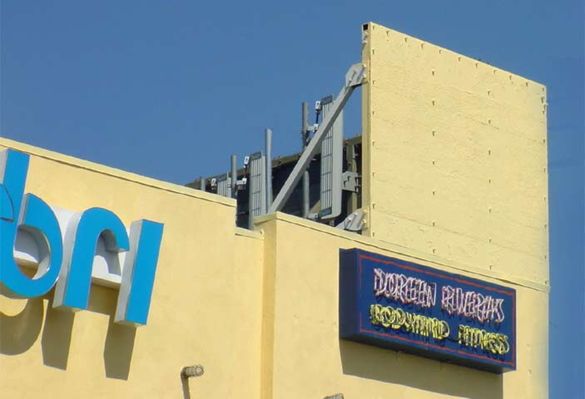 Poor Camo Design
A camo site should effectively hide the antennas from public view.  This site, in West Los Angeles, fails to do so, and illustrates the point.  Camo is NOT just putting up some antenna blinds and painting to match.
