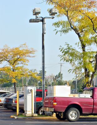 Microcell Bolted on Parking Lot Light
Spotted in Glen Ellyn, Illinois, this microcell site is bolted to the top of an existing parking lot light standard.  Notice the equipment mounted in the grass area (hey, guy, open that car door slowly or you might hit something).
Keywords: microcell parking lot