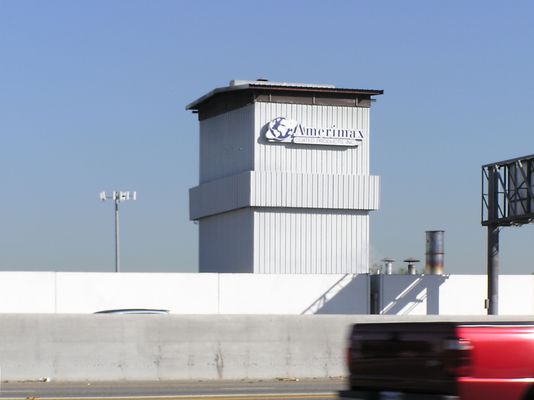 Belting out the RF
The 'belt' around the middle of this structure hides cell antennas.  Notice two things: (1) at the far end of the left side you can see some of the antenna cables; and (2) the traditional cell site behind this project.
Keywords: camo belt