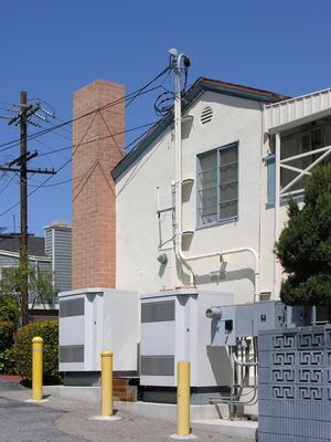 BTS Equipment, Top and Bottom of Faux Chimney
This Cingular-built site in El Segundo, California, now owned by T-Mobile, overlooks LAX.  The building houses a mortuary.  In this picture you see the BTS equipment and the cables feeding to the bottom of the faux chimney.  A steeple on the LAX side of the building serves the airport. 
Keywords: cingular t-mobile lax el segundo faux chimney steeple