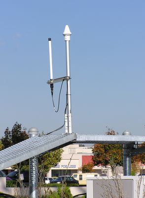 GPS and LMU antennas
The GPS antenna (the pointed white dome) is used to receive satellite-delivered timing signals used to sync a large-area wireless network. 

The LMU (Location Measuring Unit) antenna, which in this photograph is mounted on a bracket to the left of the GPS antenna) is used to help a wireless carrier locate its users as required by the FCC for wireless E-911.  
Keywords: GPS LMU