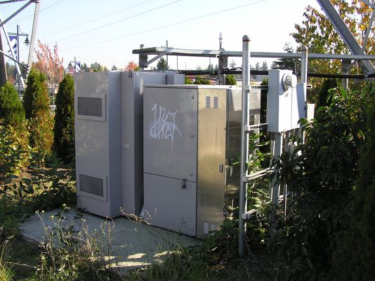 Pad-mounted Base Station
This is a concrete-pad mounted cell site base station.  The powering is to the right, and the GPS antenna is seen in the top-background attached to the ice-bridge.  The ice-bridge protects the coaxial cables, mounted below the bridge, from falling ice.
Keywords: BTS