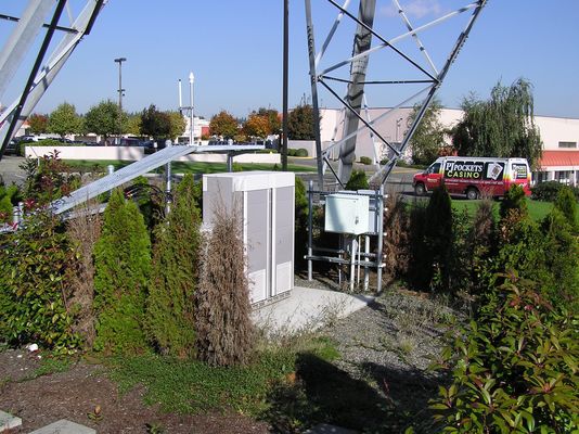 Pad-mounted Base Station
This is a concrete-mounted cell site equipment and power package.  Note the use of the ice-bridge (left-rear of the equipment) to protect the cables.  The commercial powering package is to the right of the radio equipment package. 
Keywords: BTS