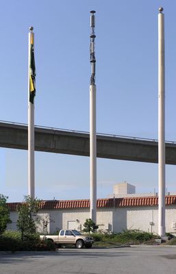 Naked Cellular/PCS Flagpole!
This is actually three photos stitched together to show the three-flagpole site in great detail. The center flagpole is an AT&T (now Cingular) Wireless site in Los Angeles, California.  AT&T shares this site with Verizon and Nextel.  The flagpole is 85' tall and 25" in diameter.  It's manufactured by Chameleon Engineering.
Keywords: Cingular faux flagpole los angeles california AT&T nextel naked