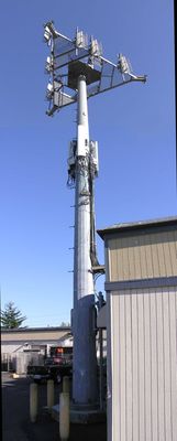 External co-location monopole
One way a co-location wireless site is created is by externally-mounting the cables and antennas to an existing monopole.  This example shows what can happen when the added cables are not covered or otherwise specified to minimize visual impact.  

The carriers at this site are Verizon Wireless and AT&T Wireless (now Cingular Wireless).
Keywords: co-location