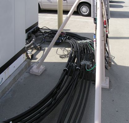 Park'n the Signal on the Roof
Notice how the coax ground wires are far from supported, attached, and protected at this site.  This is a violation of the NEC 810.21(C) and (D) et seq.
Keywords: pbms cingular t-mobile long beach parking lot roof