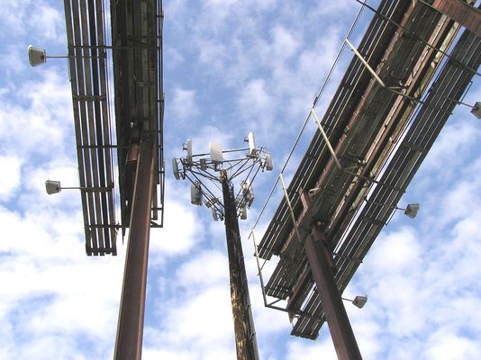 A New Sign of the Times
Yes, this cell site is sandwiched between two outdoor advertising signs.  Yes, two of the three sectors shine THROUGH the signs (with metal rails just in front of the panel antennas).  
