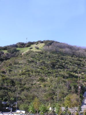 Ground level wireless site on hilltop - Overview
This is a pull-back photo of a cell site atop a hill above a major Interstate Highway.  The antennas are mounted at ground level.
