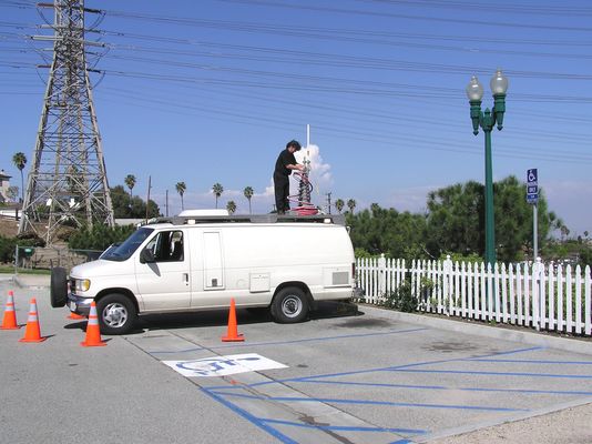 Sprint Conducts a Drive Test
The tech mounts the omnidirectional antenna to the telescoping mast. Once the antenna is mounted, he'll connect the coax that runs back to the portable PCS transmitter sitting inside the van.  Then the tech will elevate the antenna to the desired height, and set the proper output power of the transmitter.  With all this done, another tech will drive the streets in the area recording signal strength, latitude, and longitude for later mapping.
Keywords: Sprint drive test