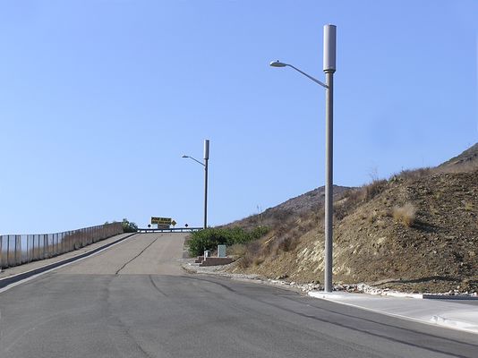 Sprint's Dual Light Standard Site
High above the US101 (Ventura Freeway) in Thousand Oaks sit these dual light standards. Two light standards provide three sectors of diversity coverage in this very high (RF) traffic area. The BTS equpment is located in the vault between the two light standards.
Keywords: sprint newbury park thousand oaks light standard dual