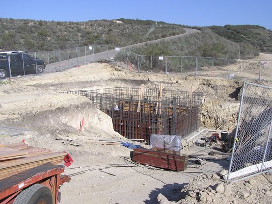 Rebar cage for underground transmitter building - From ramp
Another shot of the rebar that forms the soon-to-be underground transmitter building.  The roadway in the background goes to the antenna site, adjacent to a camouflaged water tank.
Keywords: KMLT-FM