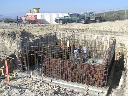 Rebar cage for underground transmitter building
Here's a good show showing how much rebar has been placed in the past 7 days (see the other photo in this gallery).  The temporary transmitter trailer is shown in the background.  Chris Hicks, the RF engineer responsible for making this site operational, is in the white shorts behind/above the excavation.
Keywords: kmlt-fm