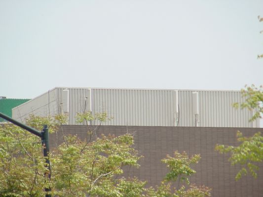 Surface mounted antennas sometimes just require matching paint
This surface mount wireless site is less visible due to the use of matching paint on the antenna radomes.  Less visible, but not a true camouflage site. 
Keywords: wireless roof matching paint cellular surface mount